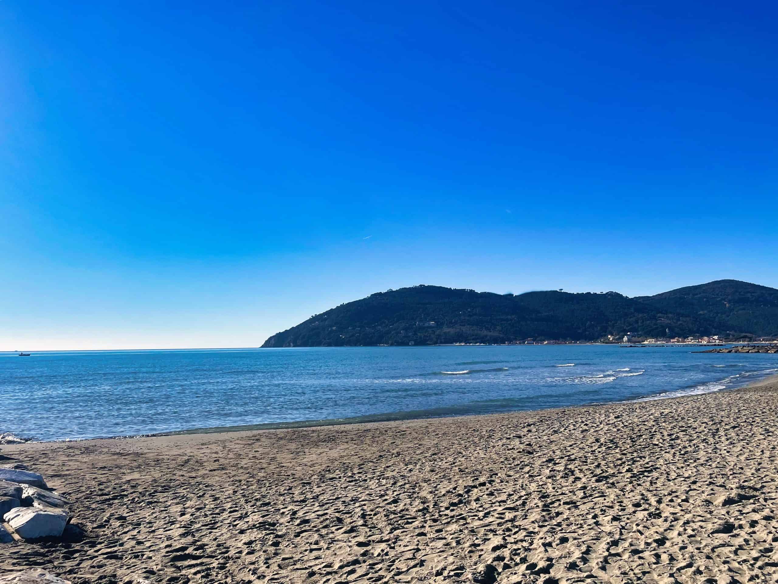 Strand mit Blick auf das Meer und die umliegenden Hügel in Luni Mare, Italien.